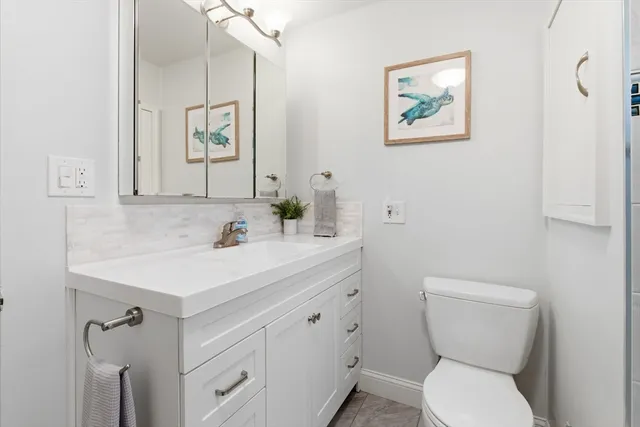 a bathroom with a toilet a sink and mirror