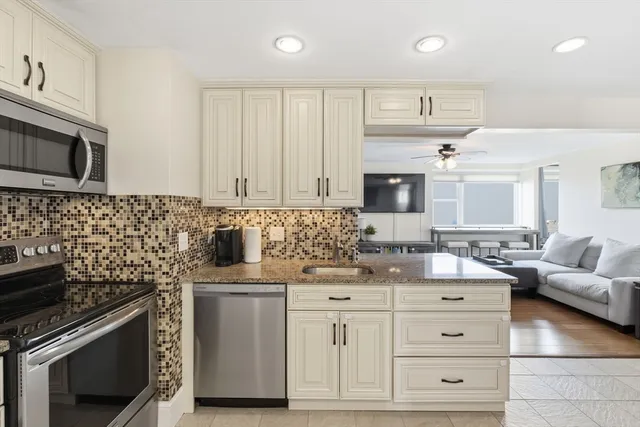 a kitchen with granite countertop a sink stove and cabinets
