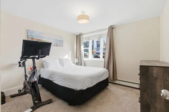 a bed room with a bed tv and a window