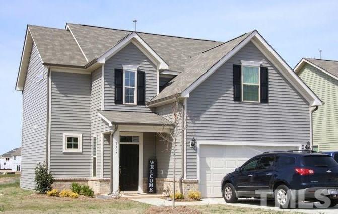 a front view of a house with cars