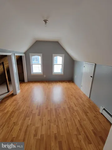 a view of an empty room with windows and fireplace