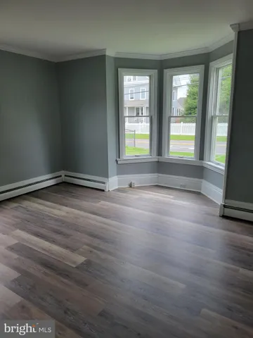 a view of an empty room with wooden floor