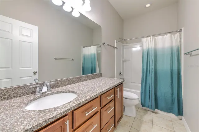 a bathroom with a granite countertop sink a mirror and a shower