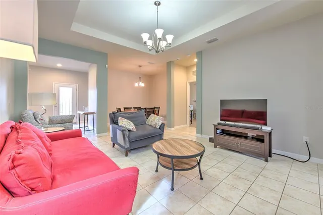 a living room with furniture and a chandelier