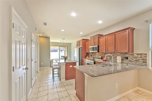 a kitchen with stainless steel appliances granite countertop a stove a sink and a refrigerator