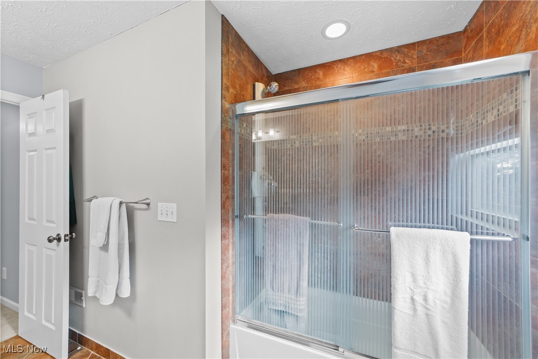 30825 Cannon Road Solon, OH 44139 - Photo 35 of 49 Bathroom with a textured ceiling, enclosed tub / shower combo, and tile patterned flooring