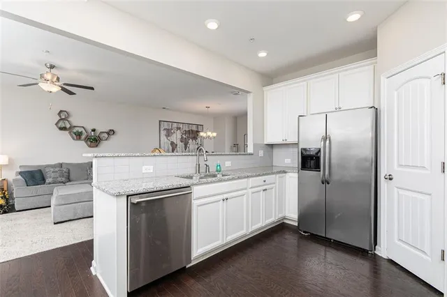 a kitchen with stainless steel appliances white cabinets and a refrigerator
