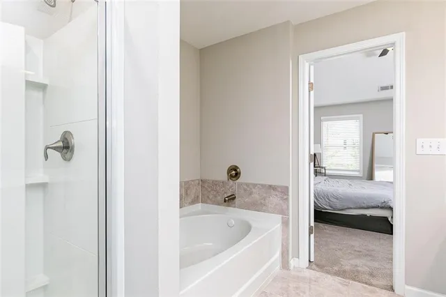 a en suite bathroom with a tub shower and a sink