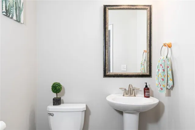 a bathroom with a toilet sink and mirror