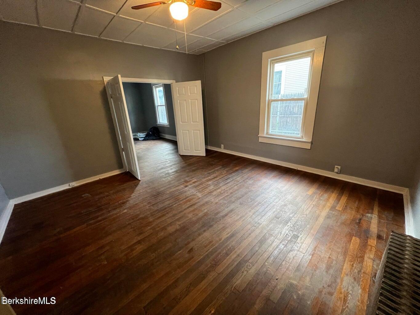 98 Lincoln Street, Unit A Pittsfield, MA 01201 - Photo 5 of 11 an empty room with wooden floor and windows