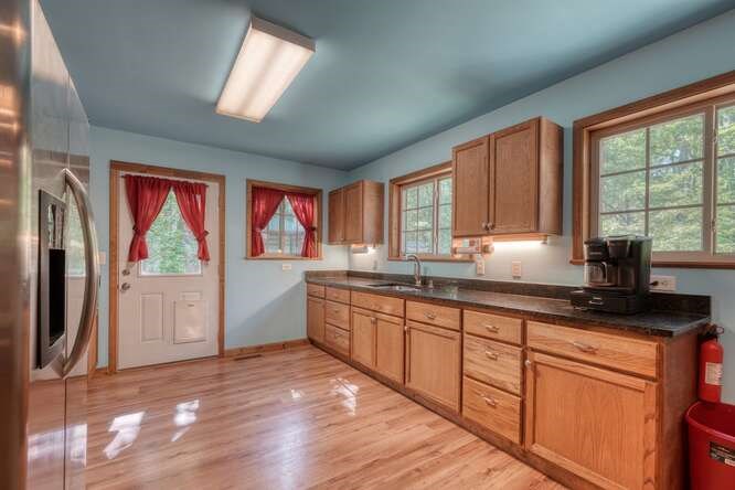 441 Foxfire Road Blairsville, GA 30512 - Photo 16 of 73 a kitchen with stainless steel appliances granite countertop a refrigerator a sink dishwasher a stove and white countertops with wooden floor