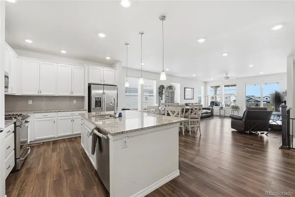 a kitchen with a sink stove and wooden floor