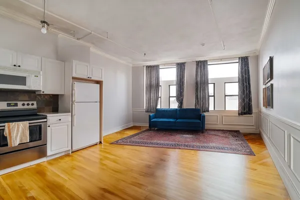 a view of a kitchen with a sink and dishwasher a refrigerator with wooden floor