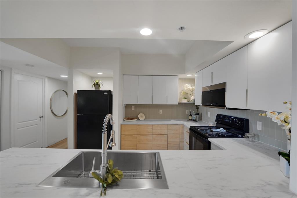 100 North Federal Highway, Unit 819 Fort Lauderdale, FL 33301 - Photo 12 of 36 a kitchen with stainless steel appliances kitchen island granite countertop a refrigerator a stove a microwave oven a sink with island and chairs