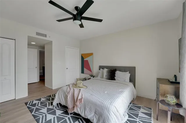 a bedroom with a bed and a flat tv screen on dresser