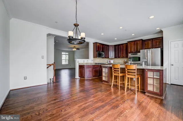 a kitchen with granite countertop wooden cabinets a refrigerator and a stove top oven