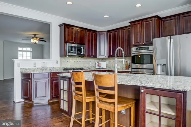 a kitchen with stainless steel appliances granite countertop a sink stove microwave and refrigerator