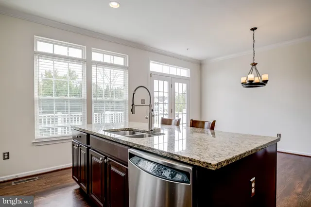 a kitchen with stainless steel appliances granite countertop sink stove refrigerator and cabinets
