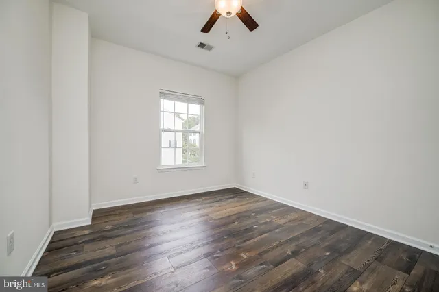 an empty room with a window and a ceiling fan