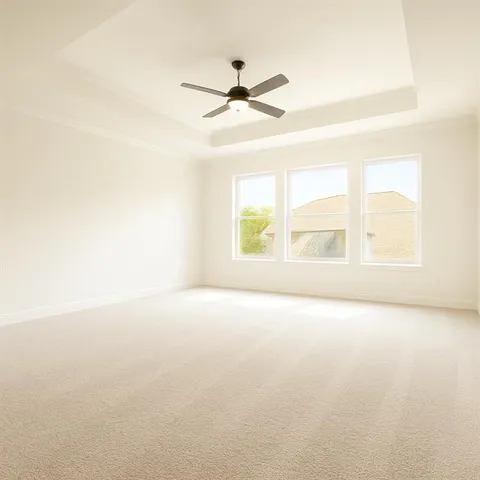 an empty room with windows and ceiling fan