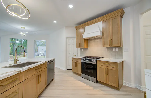 a large kitchen with stainless steel appliances granite countertop a stove a sink and a microwave