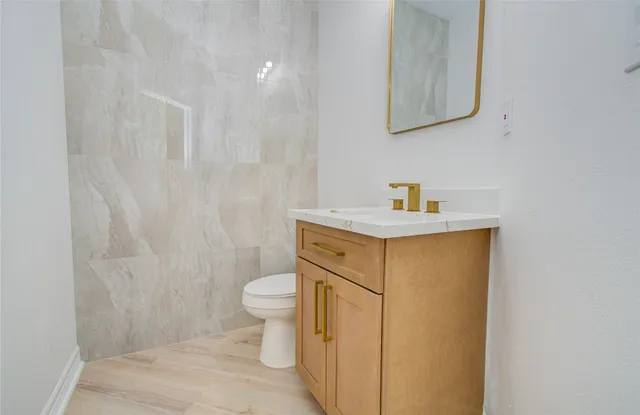 a bathroom with a granite countertop sink toilet a shower and a mirror