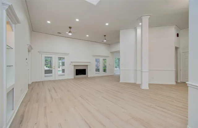 a view of empty room with wooden floor and fireplace