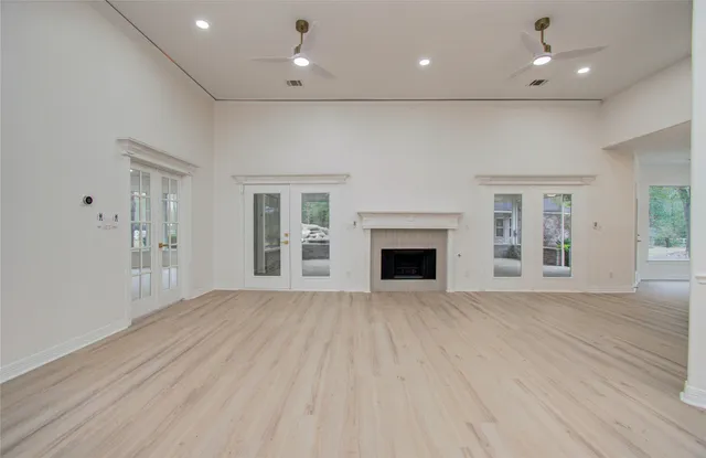 an empty room with wooden floor and fireplace