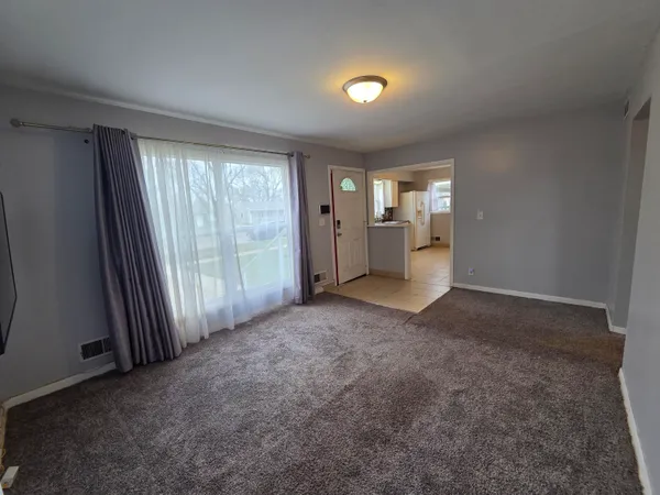 an empty room with a fireplace and large window