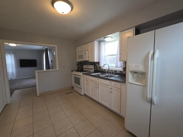 a kitchen with a refrigerator sink and cabinets
