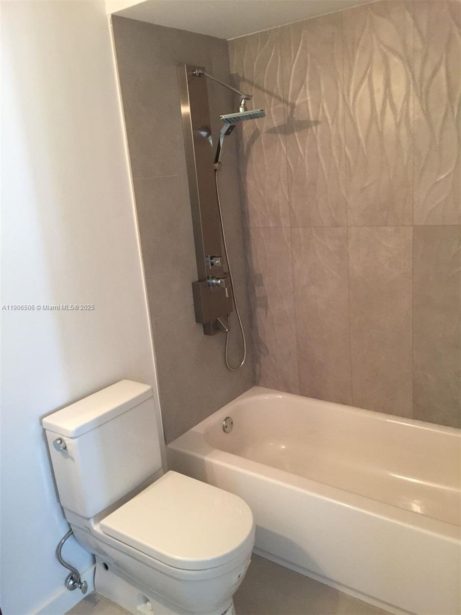551 Michigan Avenue, Unit 122 Miami Beach, FL 33139 - Photo 4 of 7 a bathroom with a toilet and a bathtub