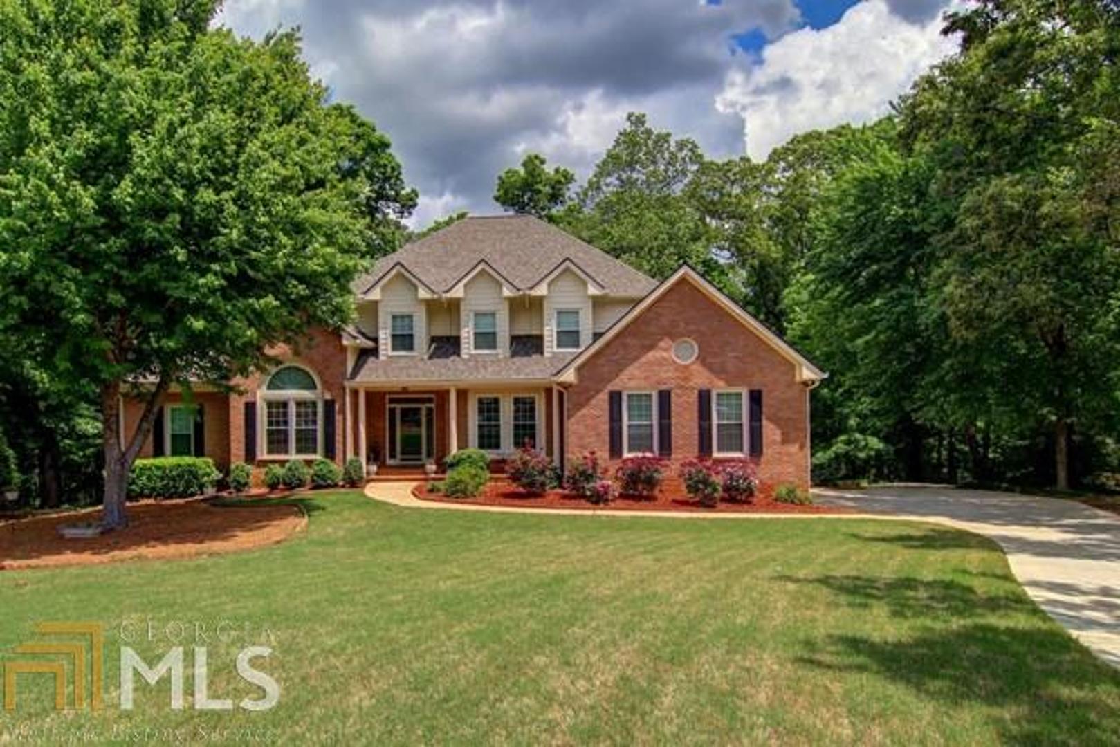 1190 Azalea Circle Southeast Conyers, GA 30013 - Photo 1 of 1 a front view of a house with a yard table and chairs