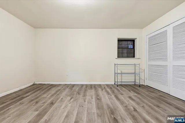 a view of a room with wooden floor and a window