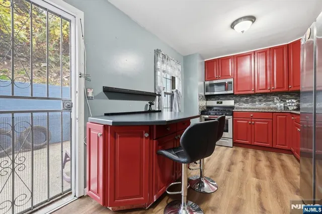 a kitchen with a sink a window and chairs