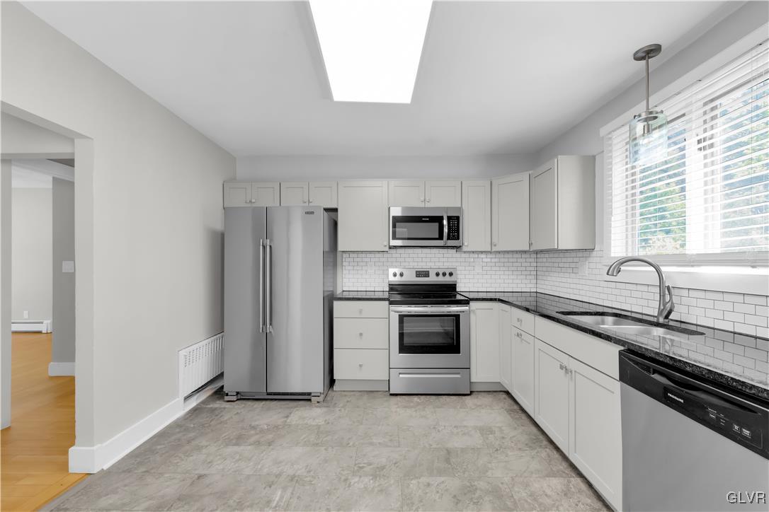820 Morvale Road Easton, PA 18042 - Photo 21 of 50 a kitchen with stainless steel appliances granite countertop white cabinets a sink a stove a refrigerator with grey cabinets