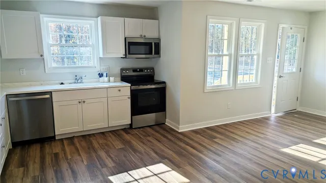 a kitchen with a sink wooden floor and a window