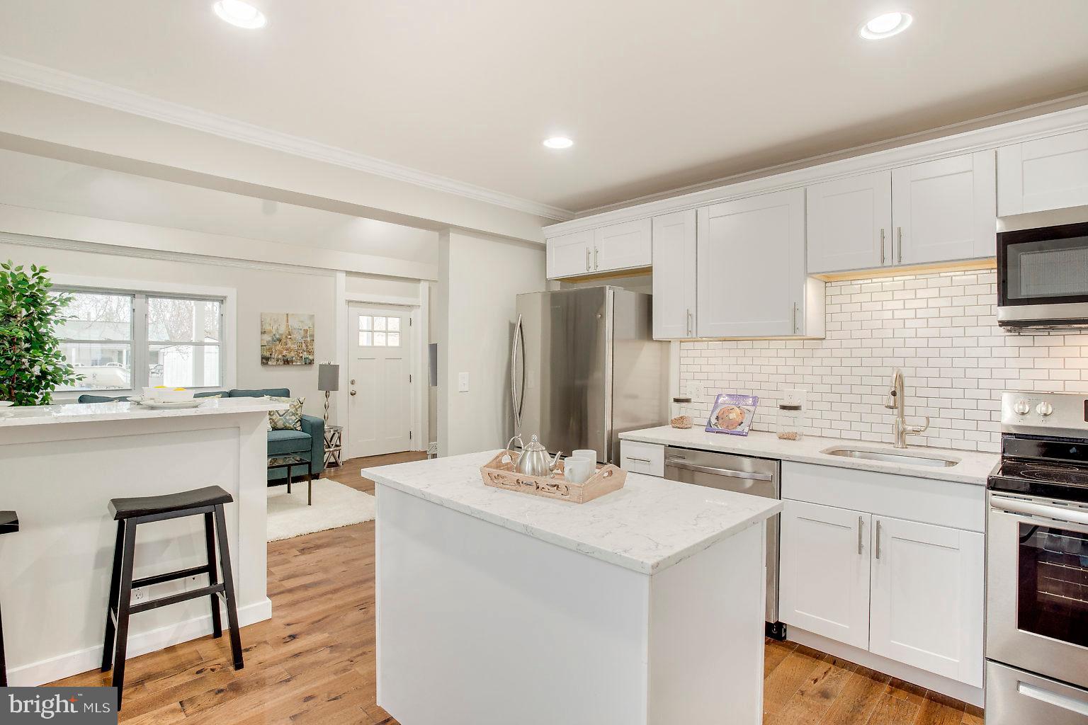 a kitchen with a sink a stove a refrigerator and white cabinets