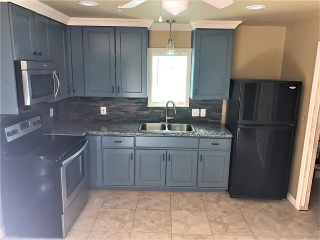a kitchen with a sink refrigerator and cabinets