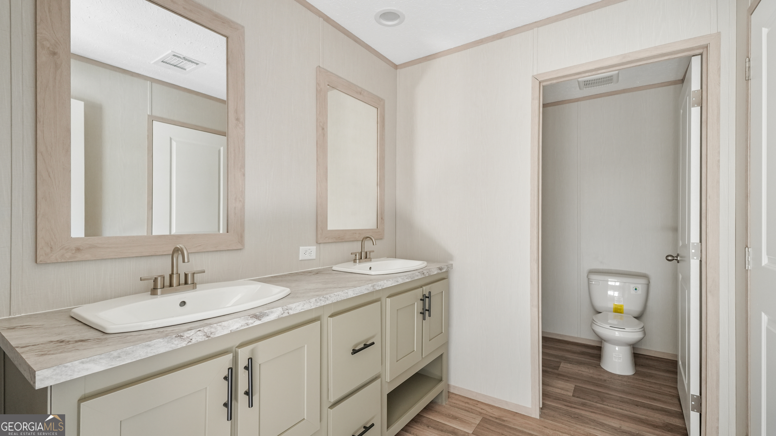 123 Daniel Street Waynesville, GA 31566 - Photo 11 of 36 a bathroom with a granite countertop sink a toilet and a mirror