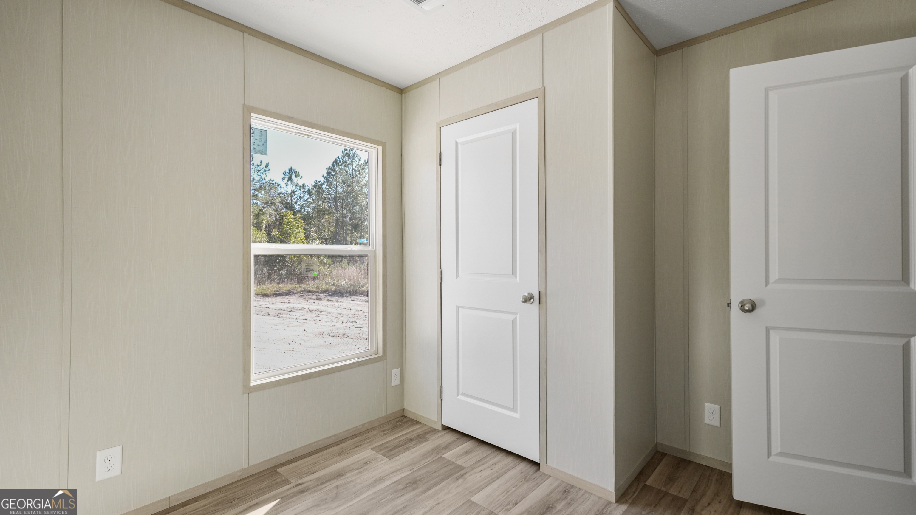 123 Daniel Street Waynesville, GA 31566 - Photo 16 of 36 a view of an empty room with wooden floor and a window