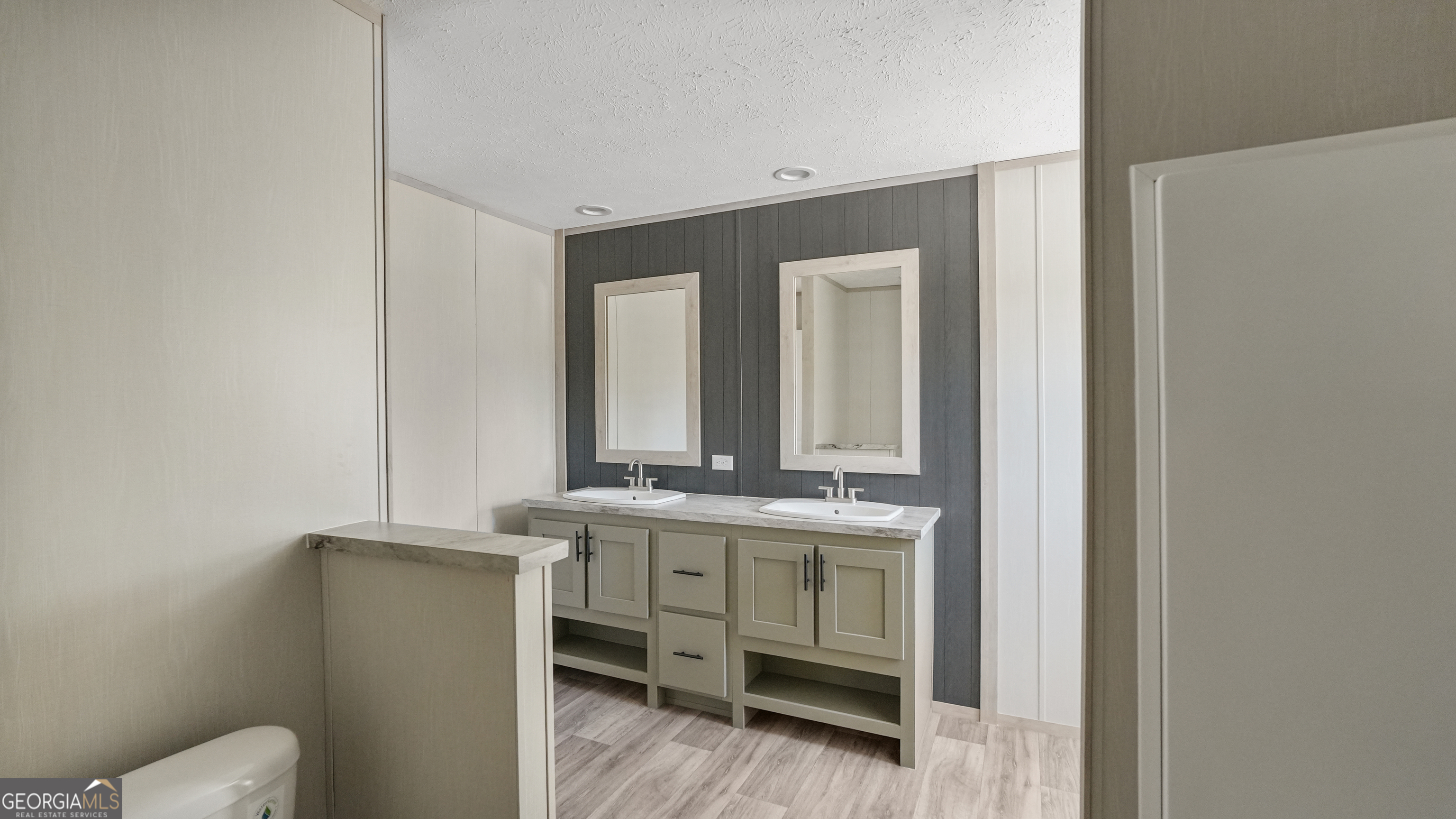 123 Daniel Street Waynesville, GA 31566 - Photo 23 of 36 a bathroom with a granite countertop toilet a sink and mirror