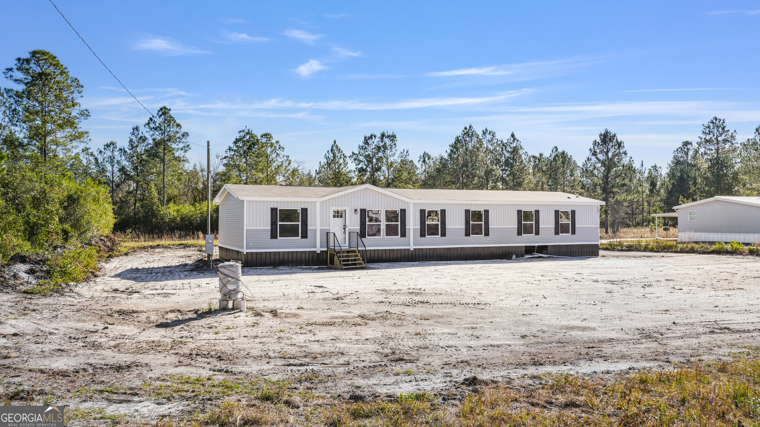 123 Daniel Street Waynesville, GA 31566 - Photo 25 of 36 a front view of a house with a garden