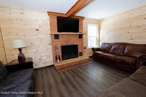 a living room with furniture a flat screen tv and a fireplace