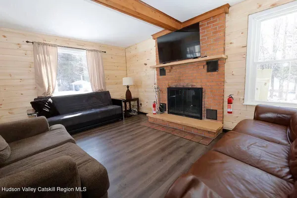 a living room with furniture a flat screen tv and a fireplace