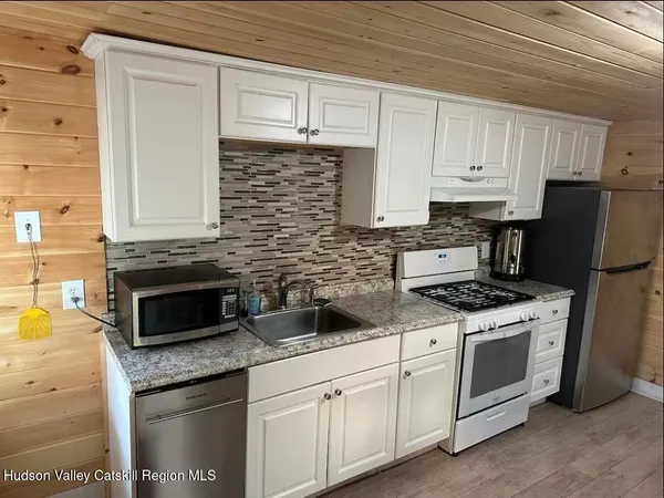 a kitchen with stainless steel appliances granite countertop white cabinets and white appliances