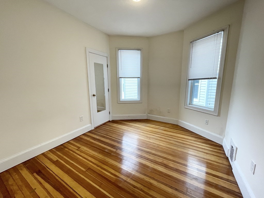 31 Edison Green, Unit 2 Boston, MA 02125 - Photo 11 of 16 a view of an empty room with wooden floor and a window