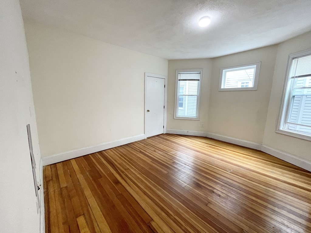 31 Edison Green, Unit 2 Boston, MA 02125 - Photo 12 of 16 an empty room with wooden floor and windows