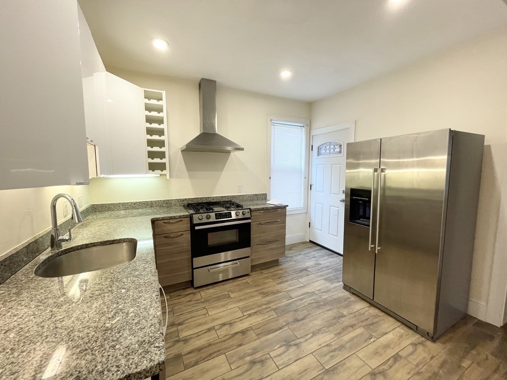 31 Edison Green, Unit 2 Boston, MA 02125 - Photo 2 of 16 a kitchen with stainless steel appliances granite countertop a sink stove and refrigerator
