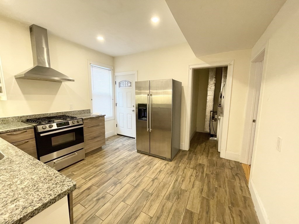 31 Edison Green, Unit 2 Boston, MA 02125 - Photo 3 of 16 a kitchen with stainless steel appliances a stove a refrigerator and cabinets