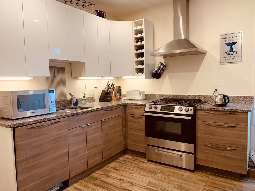 31 Edison Green, Unit 2 Boston, MA 02125 - Photo 4 of 16 a kitchen with stainless steel appliances granite countertop a stove and a sink